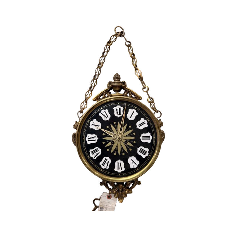 Vintage ornate German brass hanging wall clock in Classical Revival style with a black face and engraved gold center.